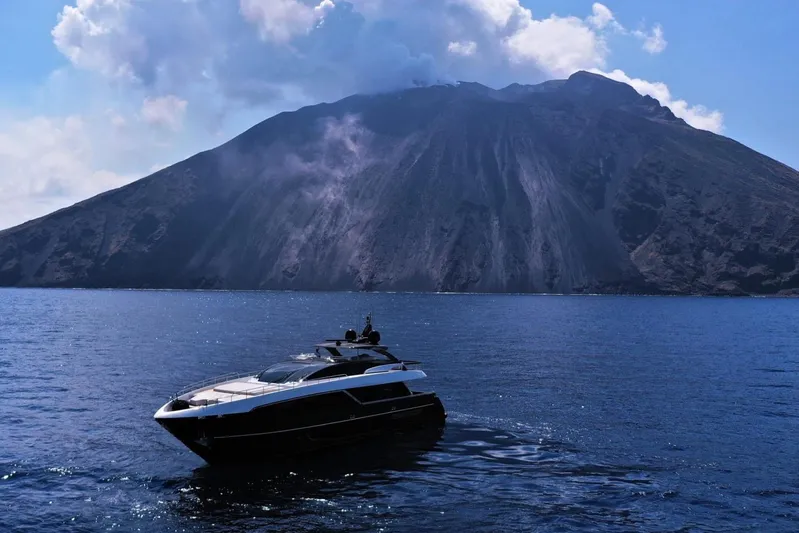 Ruzarija Yacht Photos Pics Luxurious 2020 Riva 100' Corsaro yacht cruising near a volcanic island.