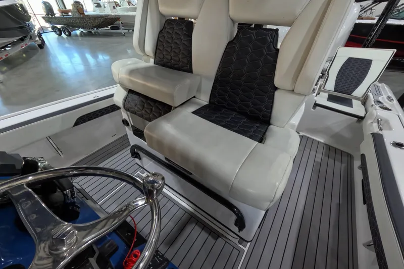  Yacht Photos Pics 2024 Tidewater boat interior with luxurious seating and sleek steering wheel design.