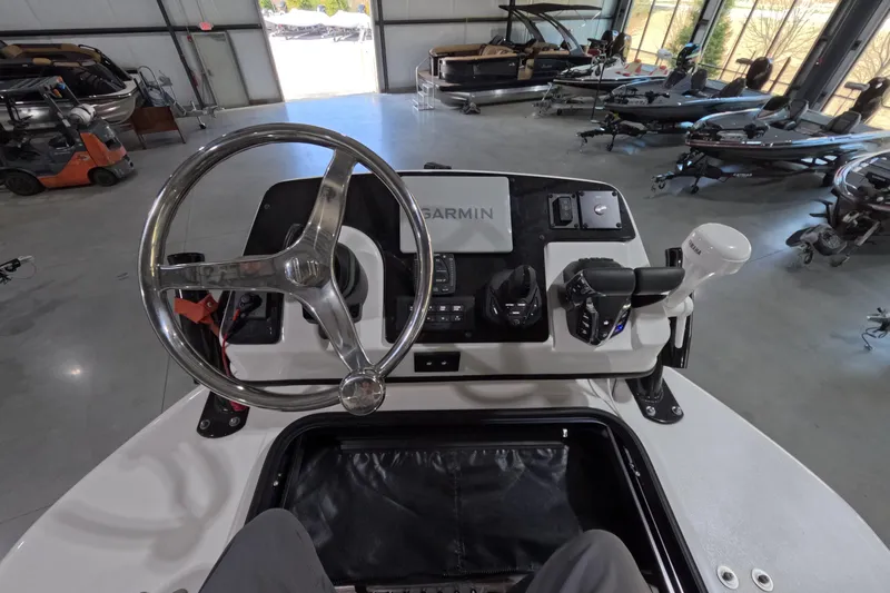  Yacht Photos Pics 2024 Tidewater boat helm with Garmin navigation, steering wheel, and controls in a showroom.