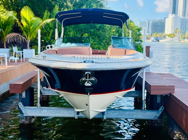  Yacht Photos Pics 2015 Chris-Craft Launch 32 boat docked, surrounded by lush greenery and urban skyline.