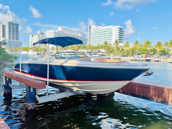 Yacht Photos Pics 2015 Chris-Craft Launch 32 boat docked in a sunny marina with cityscape background.