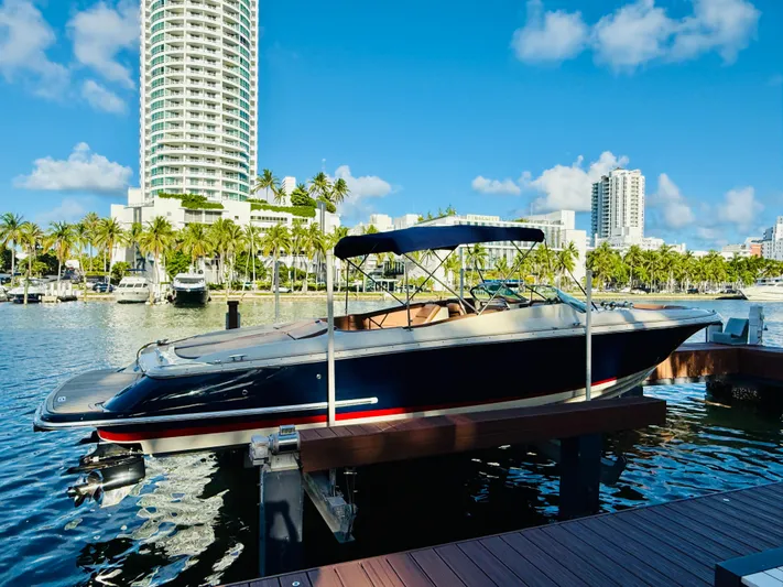  Yacht Photos Pics 2015 Chris-Craft Launch 32 docked, with city skyline and palm trees in the background.