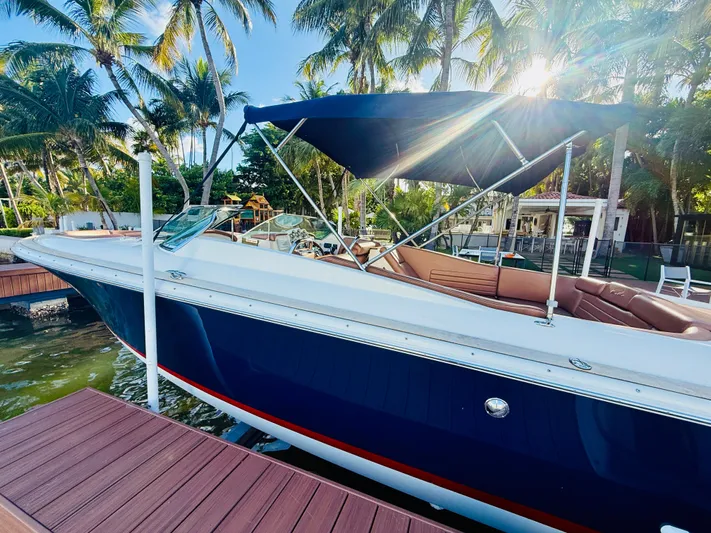  Yacht Photos Pics 2015 Chris-Craft Launch 32 boat docked under palm trees, with sun shining through canopy.