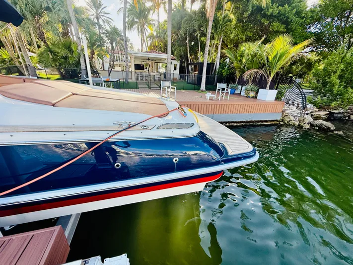  Yacht Photos Pics 2015 Chris-Craft Launch 32 docked by tropical waterfront with lush greenery.