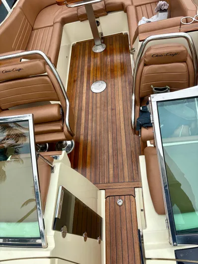  Yacht Photos Pics 2015 Chris-Craft Launch 32 interior with brown leather seats and wooden flooring.