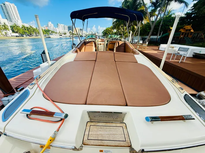  Yacht Photos Pics 2015 Chris-Craft Launch 32 boat docked by a scenic waterfront with palm trees.