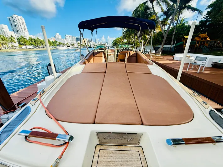  Yacht Photos Pics 2015 Chris-Craft Launch 32 boat docked by a scenic waterfront with palm trees.