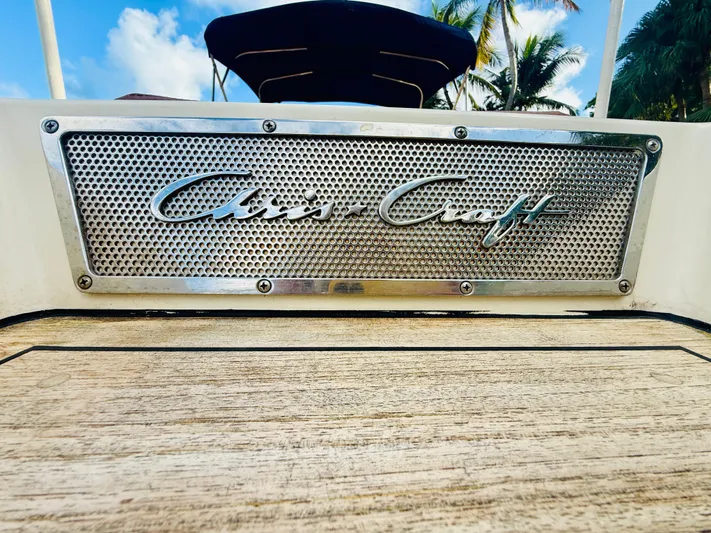  Yacht Photos Pics 2015 Chris-Craft Launch 32 boat logo on wooden deck, tropical background.