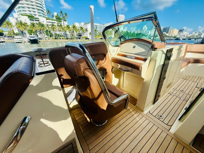  Yacht Photos Pics 2015 Chris-Craft Launch 32 interior with brown leather seats and wooden flooring.