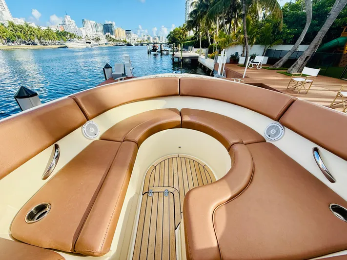  Yacht Photos Pics 2015 Chris-Craft Launch 32 boat with luxurious seating, docked by a scenic waterfront.