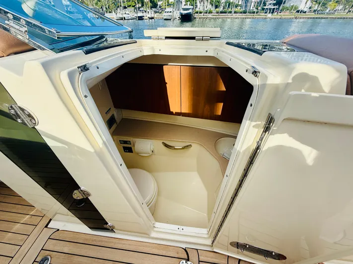  Yacht Photos Pics 2015 Chris-Craft Launch 32 boat interior with open cabin door, showcasing compact bathroom.