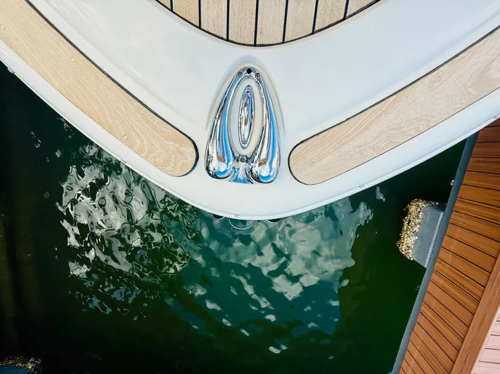  Yacht Photos Pics 2015 Chris-Craft Launch 32 boat bow with teak decking, docked on calm water.