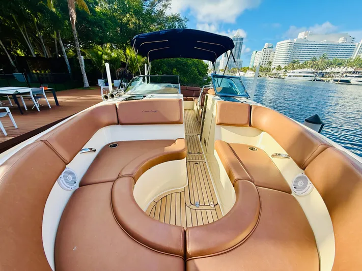  Yacht Photos Pics 2015 Chris-Craft Launch 32 boat with luxurious seating, docked by a scenic waterfront.