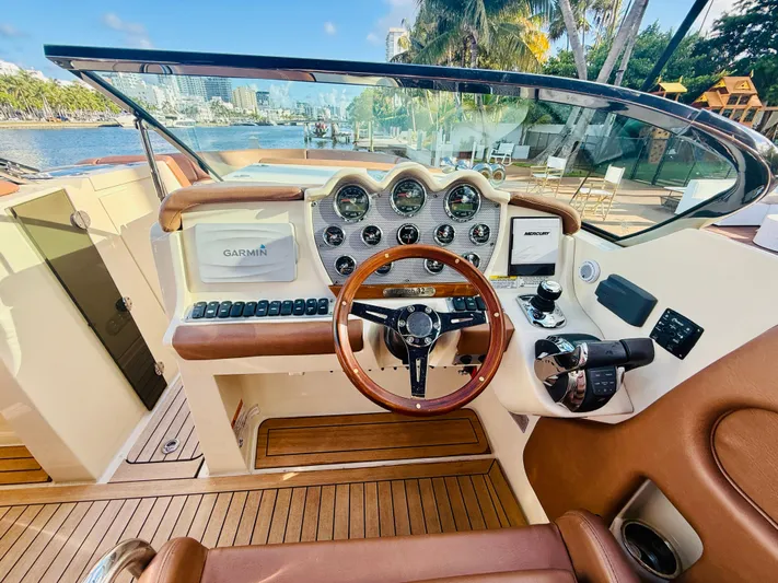  Yacht Photos Pics 2015 Chris-Craft Launch 32 dashboard with Garmin navigation, wooden steering wheel, and luxurious interior.