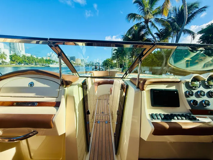  Yacht Photos Pics 2015 Chris-Craft Launch 32 boat interior with dashboard, palm trees, and waterfront view.
