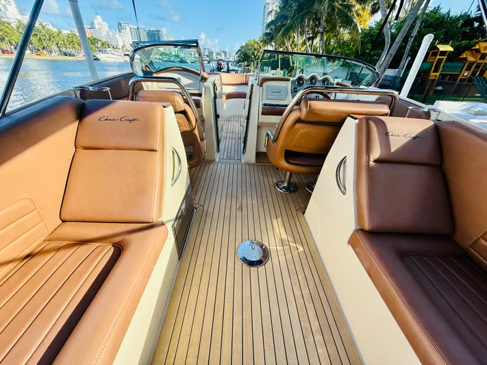  Yacht Photos Pics 2015 Chris-Craft Launch 32 boat interior with brown leather seats and wooden deck.