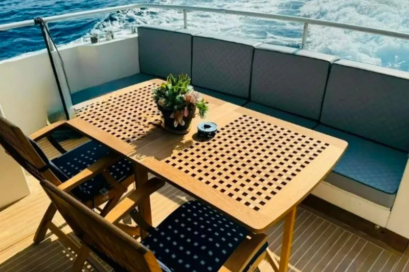  Yacht Photos Pics Outdoor seating on 1991 Dalla Pieta 52 Asterion yacht with wooden table and ocean view.