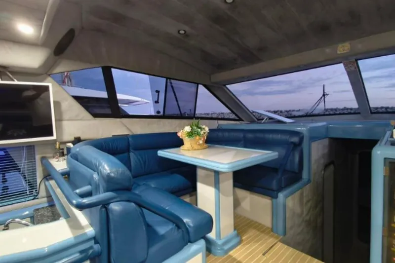  Yacht Photos Pics Luxurious interior of 1991 Dalla Pieta 52 Asterion yacht with blue seating and dining area.