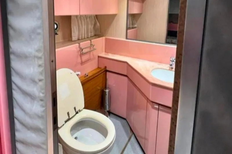  Yacht Photos Pics Pink bathroom interior of 1991 Dalla Pieta 52 Asterion yacht, featuring toilet and sink.