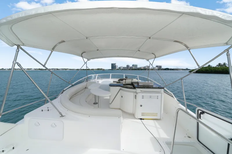 Mimosa Yacht Photos Pics 2001 Cruisers Yachts 5000 Sedan Sport, spacious deck with canopy, overlooking serene waters.