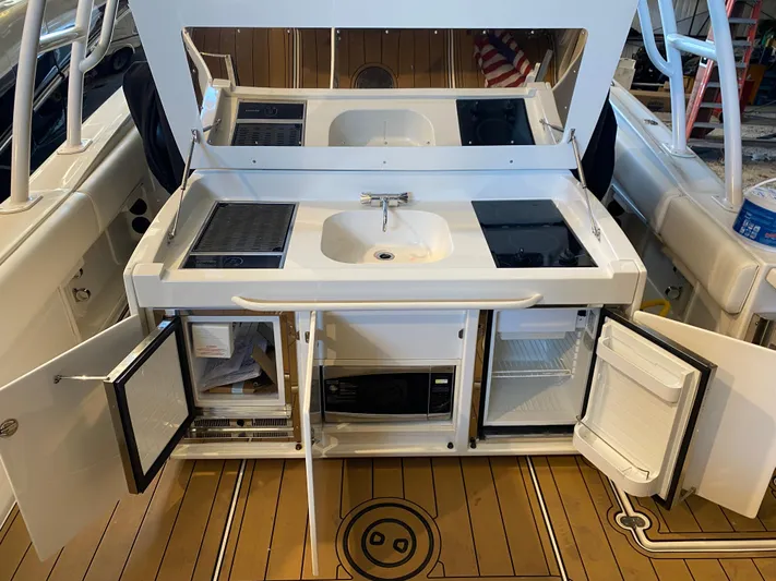Apres Sea Yacht Photos Pics 2016 Chris-Craft Catalina 34 boat kitchen with sink, stove, and storage compartments.