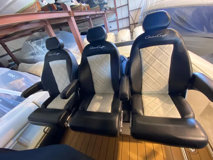 Apres Sea Yacht Photos Pics Three luxurious black and white seats on a 2016 Chris-Craft Catalina 34 boat.