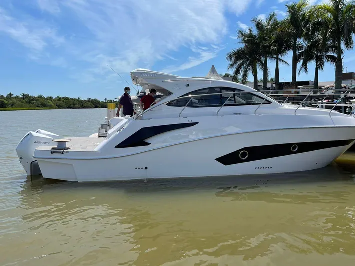  Yacht Photos Pics 2022 Evolve 360HT yacht docked by palm trees on a sunny day.