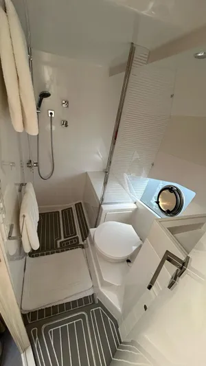  Yacht Photos Pics Modern bathroom in 2022 Evolve 360HT yacht, featuring shower, toilet, and porthole window.