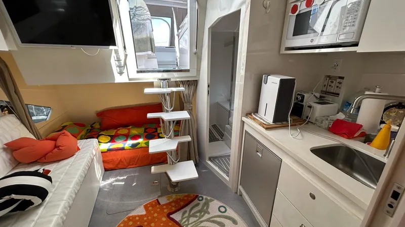  Yacht Photos Pics Compact interior of 2022 Evolve 360HT camper with modern kitchen, cozy seating, and colorful bedding.