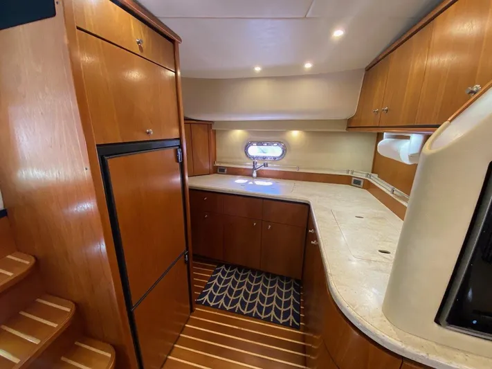 Kostas More Yacht Photos Pics Interior of 2009 Tiara Yachts 4300 Sovran with wood cabinetry and kitchenette.