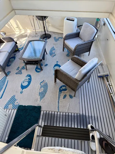 Journey's End Yacht Photos Pics Californian 48MY 1989 yacht deck with rattan furniture and fish-patterned rug.