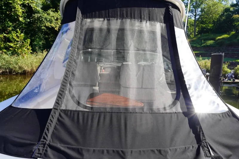  Yacht Photos Pics 2010 Sea Ray 370 Sundancer with black canvas cover, docked near lush greenery.