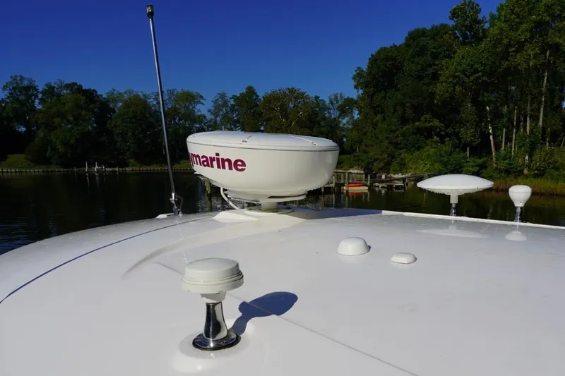  Yacht Photos Pics 2010 Sea Ray 370 Sundancer boat deck with radar, docked near lush greenery.