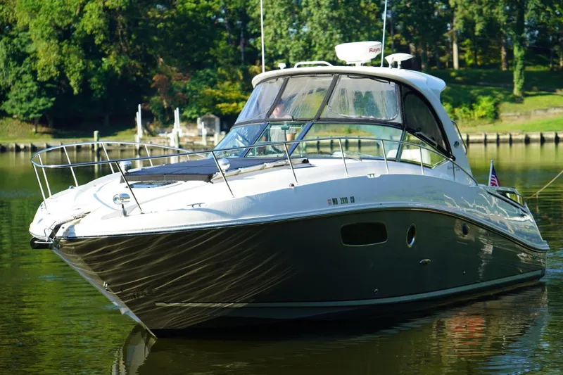  Yacht Photos Pics 2010 Sea Ray 370 Sundancer yacht on calm water, surrounded by lush greenery.