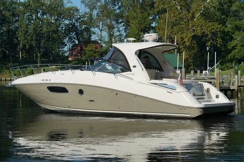  Yacht Photos Pics 2010 Sea Ray 370 Sundancer yacht on calm water, surrounded by trees.