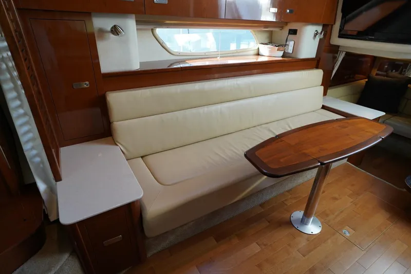  Yacht Photos Pics Luxurious interior of 2010 Sea Ray 370 Sundancer with cream sofa and wooden table.