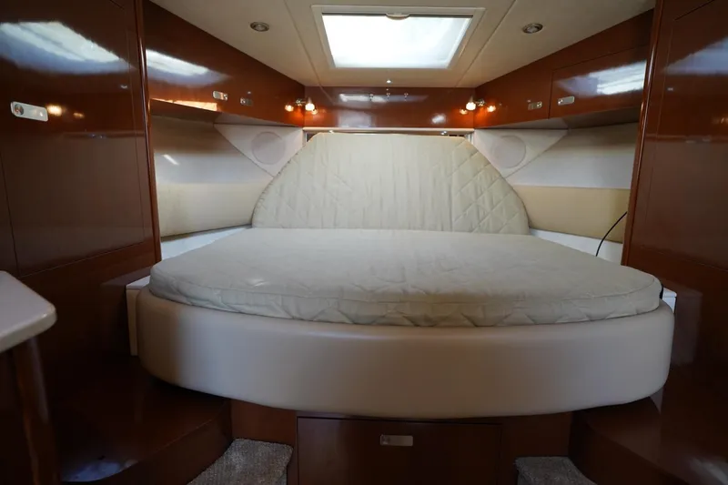  Yacht Photos Pics Luxurious cabin interior of 2010 Sea Ray 370 Sundancer with cozy bed and wooden finish.