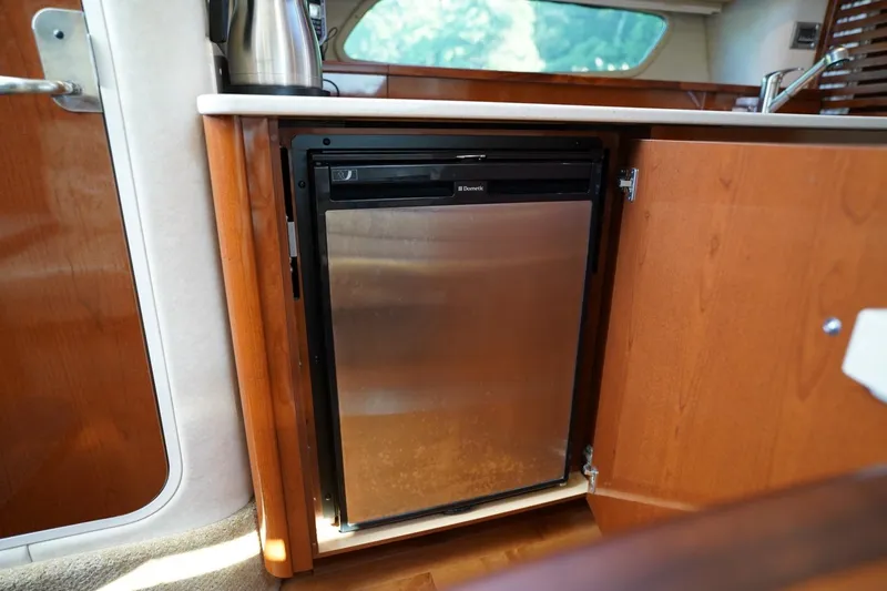  Yacht Photos Pics 2010 Sea Ray 370 Sundancer interior with compact stainless steel fridge in wooden cabinetry.