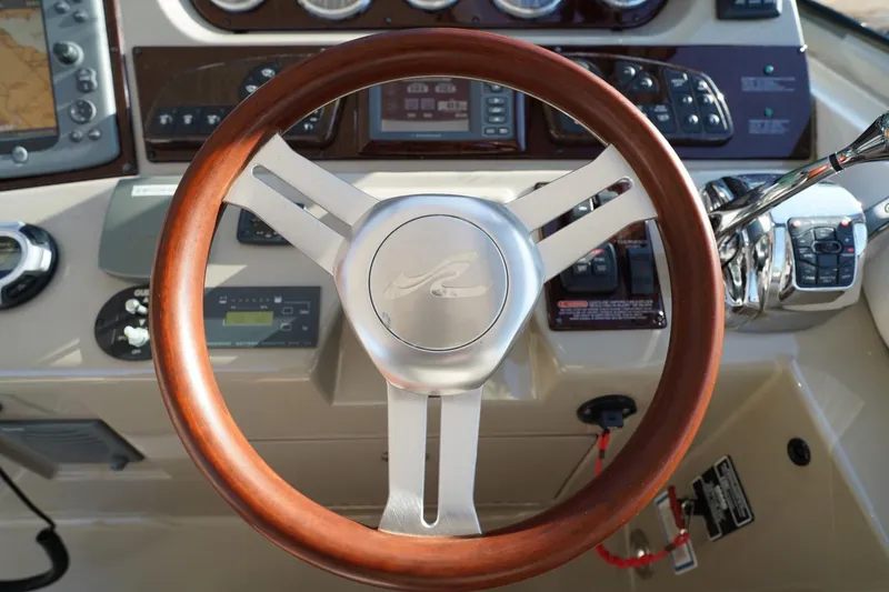  Yacht Photos Pics Steering wheel of 2010 Sea Ray 370 Sundancer boat, featuring wood and metal design.