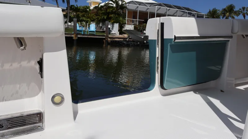  Yacht Photos Pics 2019 Everglades 435 Center Console boat with open side door, docked by water.