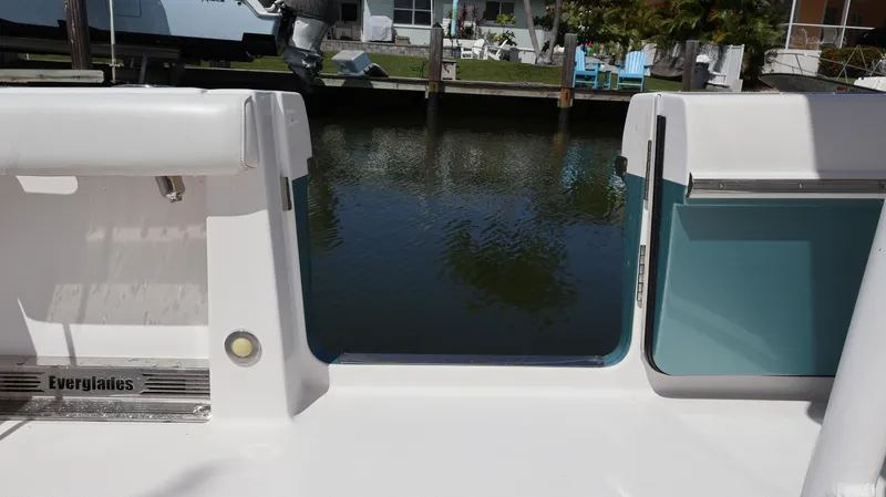 Yacht Photos Pics 2019 Everglades 435 Center Console boat, rear view, docked by a calm waterfront.