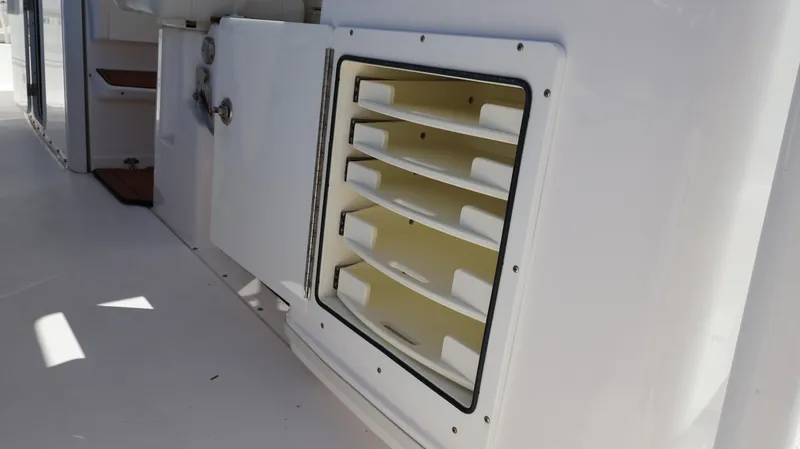  Yacht Photos Pics Storage compartment on 2019 Everglades 435 Center Console boat, featuring organized shelving.