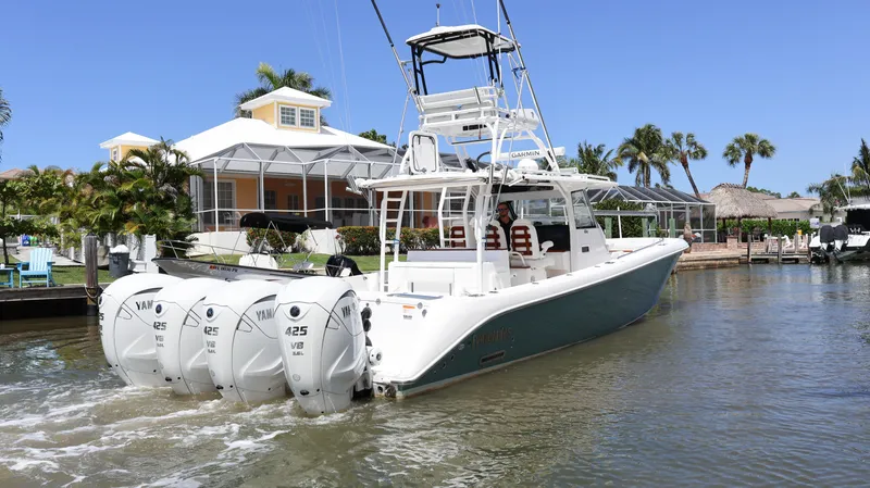  Yacht Photos Pics 2019 Everglades 435 Center Console boat with four engines, docked near a waterfront house.
