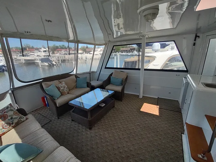  Yacht Photos Pics Spacious interior of 1995 Hatteras 52 Cockpit Motor Yacht with comfortable seating and marina view.