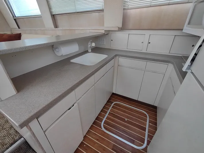  Yacht Photos Pics 1995 Hatteras 52 Cockpit Motor Yacht kitchen with white cabinets and wood flooring.