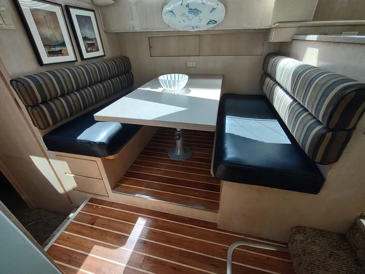  Yacht Photos Pics 1995 Hatteras 52 Cockpit Motor Yacht interior with striped seating and wooden flooring.