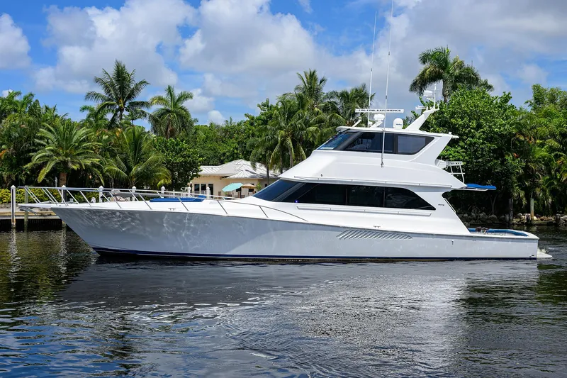  Yacht Photos Pics 2001 Viking 65 Enclosed Bridge yacht on calm water, surrounded by lush greenery.