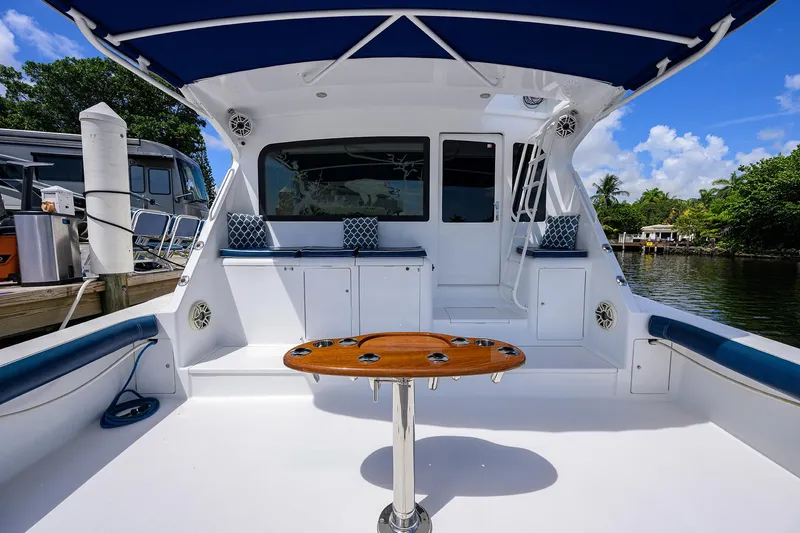  Yacht Photos Pics 2001 Viking 65 Enclosed Bridge yacht deck with seating and table, docked by water.