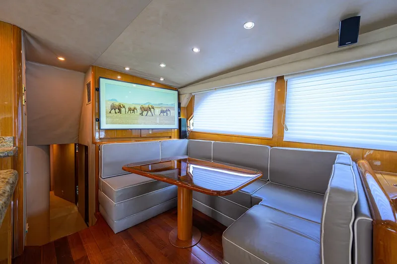  Yacht Photos Pics Luxurious interior of 2001 Viking 65 Enclosed Bridge yacht with elegant seating and wooden finishes.