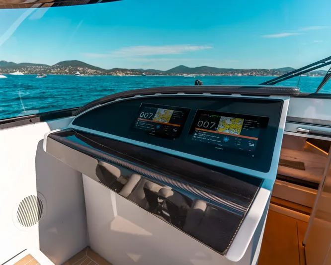 Greenwich Yacht Photos Pics Cockpit view of 2022 Wajer 55 yacht with navigation screens, ocean, and distant hills.